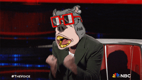 a man wearing a dog mask and sunglasses is sitting in front of a nbc sign