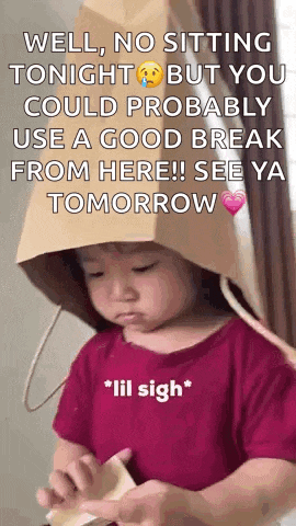 a little girl wearing a paper bag hat with a message on it