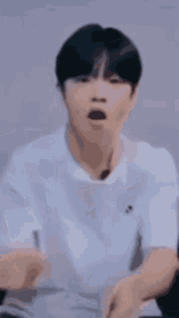 a close up of a person wearing a white t-shirt and a black necklace .