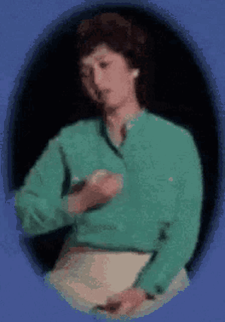a woman in a green shirt is holding a piece of paper