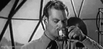 a black and white photo of a man drinking from a bottle .