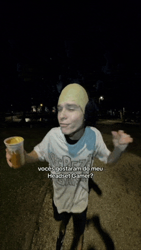 a man wearing ear muffs and a headset is holding a cup of ice cream