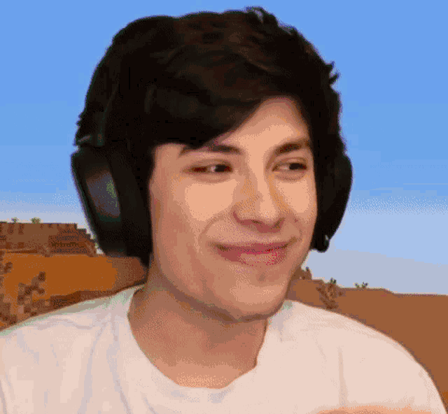 a close up of a man wearing headphones and a white shirt .