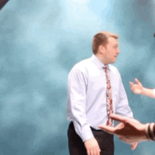 a man in a tie is shaking hands with another man .