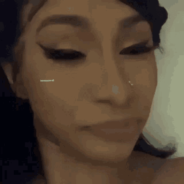 a close up of a woman 's face with a nose ring and eyeliner .