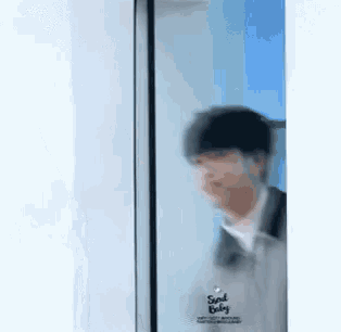a man is standing in front of a glass door .