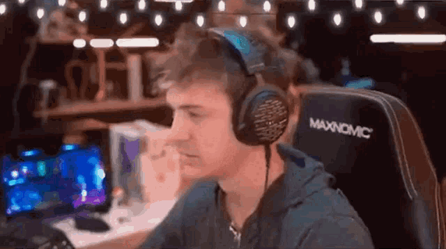 a man wearing headphones is sitting in a chair in front of a computer screen .