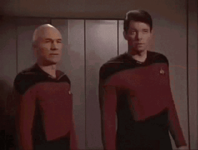 a man in a star trek uniform is sitting in a chair with lasers coming out of his face
