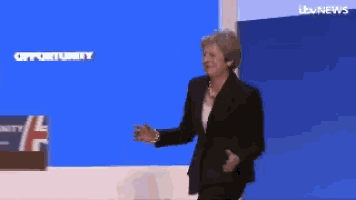 a woman in a suit stands in front of a screen that says opportunity