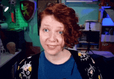 a woman with red hair is smiling in front of a shelf with n7 written on it