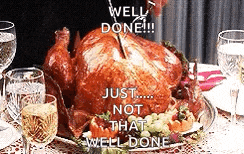 a roasted turkey is sitting on a plate on a table with glasses of wine and water .