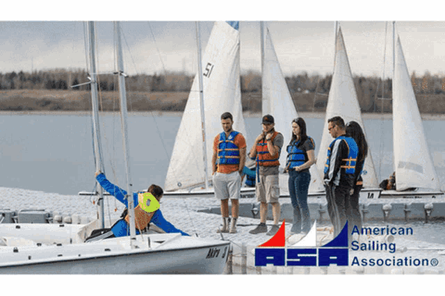 a group of people are standing on a dock next to sailboats with the asa logo in the foreground