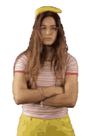 a woman with a banana on her head stands with her arms crossed
