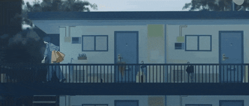 a man walking down a balcony in front of a building with blue doors
