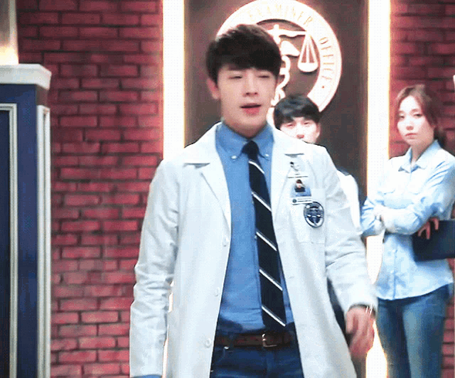 a man in a lab coat has a name tag on his chest that says ' a.m.p. office '