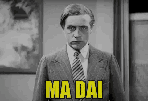a man in a suit and tie says ma dai in yellow letters .