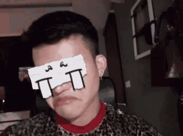 a person with a piece of paper on their eye that says tt on it