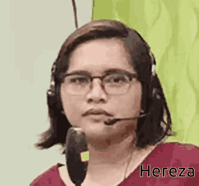 a woman wearing glasses and a headset is talking into a microphone with the name hereza written on the bottom