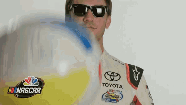 a man wearing sunglasses is holding a beach ball in front of him .