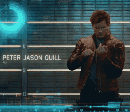 a man in a leather jacket is standing in front of a wall with the name peter jason quill on it