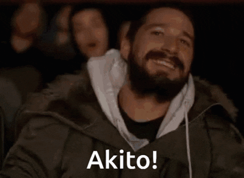 a man with a beard is sitting in a movie theater and smiling .