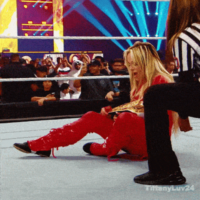 a woman in a red outfit is sitting on the ground in a wrestling ring with the words tiffanyluv24 on the bottom