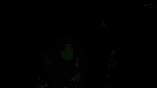 a man wearing sunglasses and a green shirt is reading a book in the dark