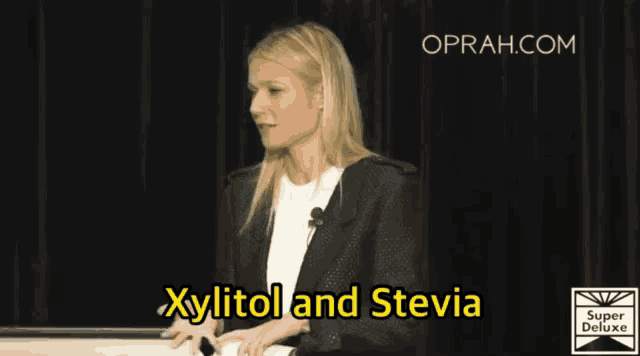 a woman stands at a podium with the words xylitol and stevia above her