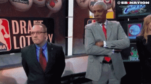 two men are standing in front of a sign that says draft lottery on it