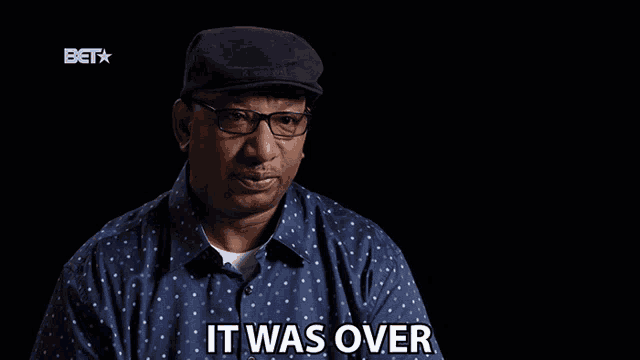 a man wearing glasses and a hat is saying it was over
