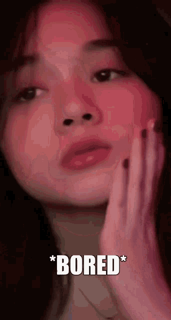 a close up of a woman 's face with the words `` bored '' written below her .