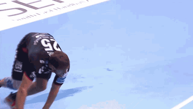 a man wearing a number 2 jersey is kneeling on the floor
