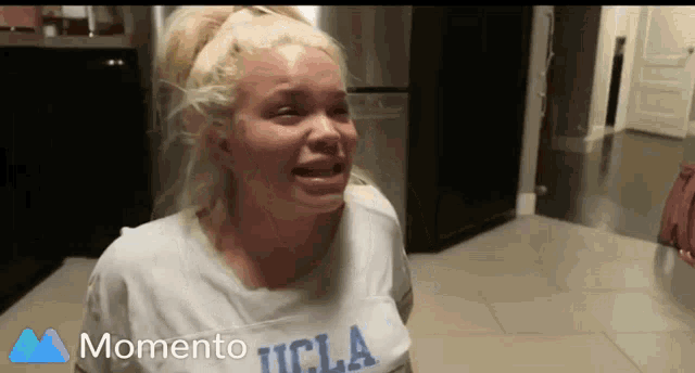 a woman in a ucla shirt is crying