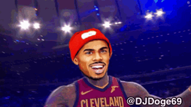 a man wearing a cleveland jersey and a red beanie