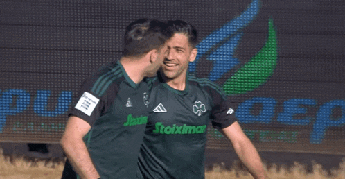 two soccer players are wearing shirts that say stoixima on them