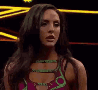a woman is making a funny face with her tongue out while wearing a wrestling outfit .