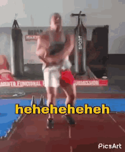 a man is dancing in a gym with the words ' heneheneh ' on the bottom right