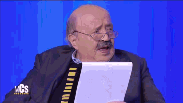 a man with glasses and a mustache is holding a piece of paper with mcs written on it