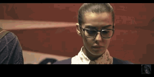 a close up of a woman wearing glasses and a white shirt