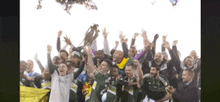 a group of soccer players are celebrating with a trophy in their hands