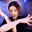 a woman is holding her hands out in front of her face and looking at the camera .