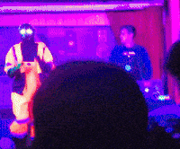a man in a costume with glow in the dark eyes is standing on a stage