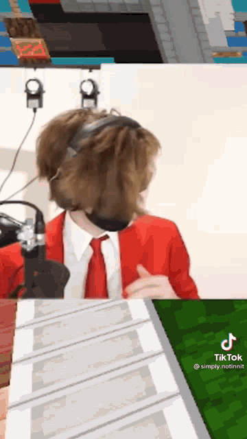 a man in a red suit and tie is wearing headphones and a mask while playing a video game .