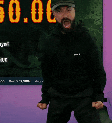 a man in a black hoodie is dancing in front of a screen that says 50.6
