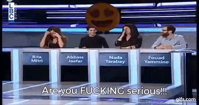 a group of people sitting at a table with the words " are you fucking serious "