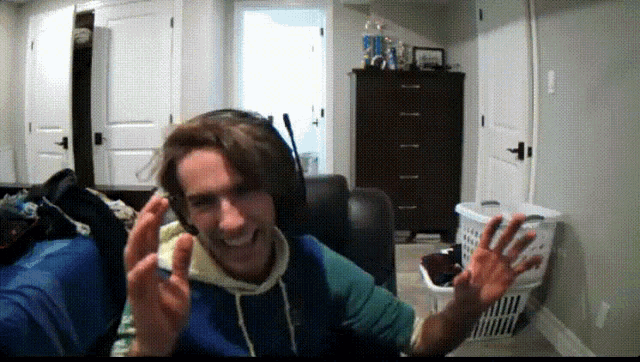 a man wearing headphones is waving his hands in a room