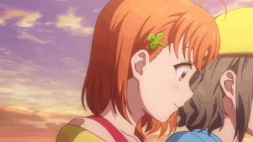 a girl with a green flower in her hair looks at another girl