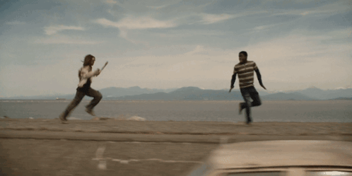 a man and a woman are running on a beach