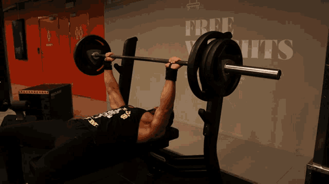 a man is lifting a barbell on a bench in front of a sign that says free yachts