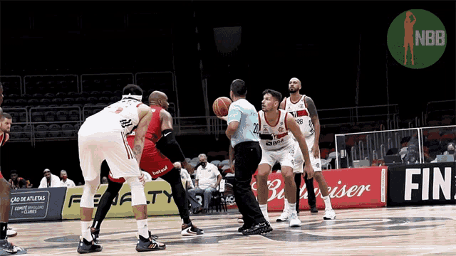 a basketball game is being played on a court with a budweiser ad in the background